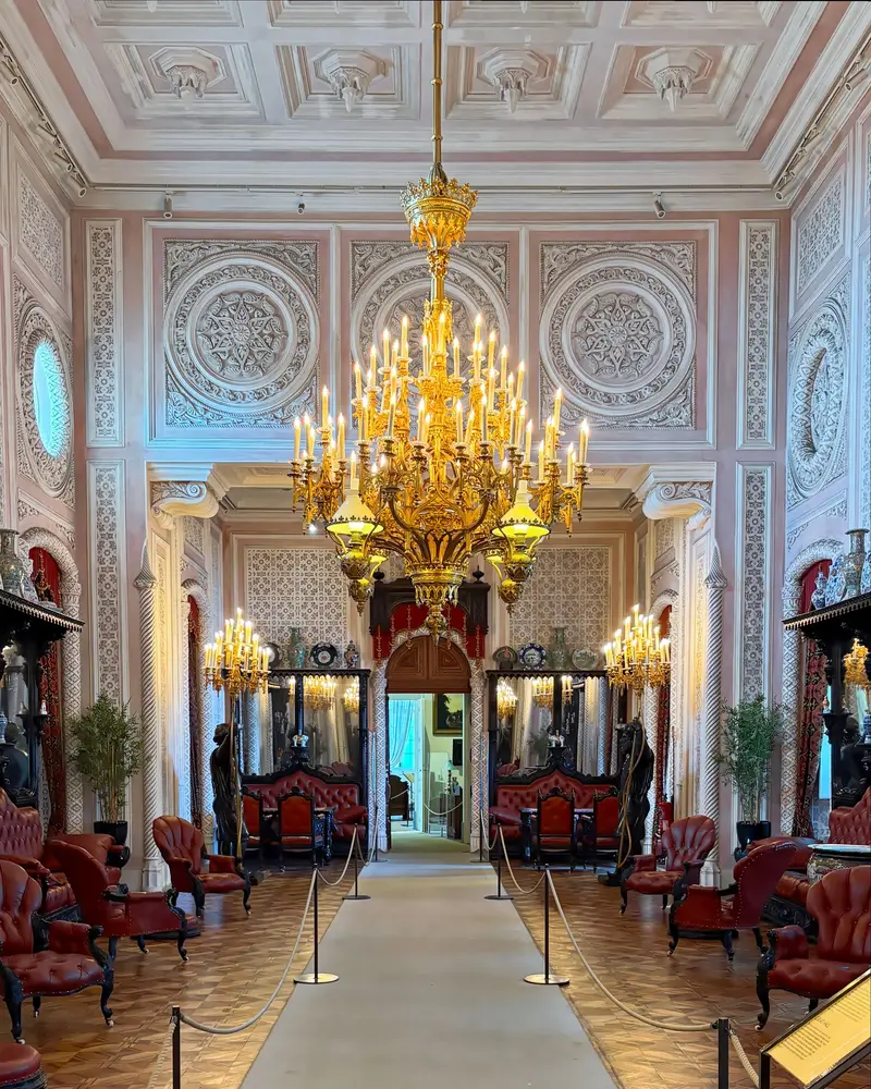 Salão do Palácio da Pena com decoração dourada, candeeiros e mobiliário de época