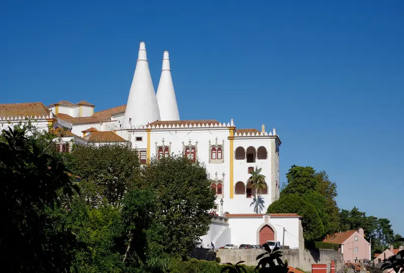 The twin white conical chimneys of the National Palace of Sintra above the town rooftops